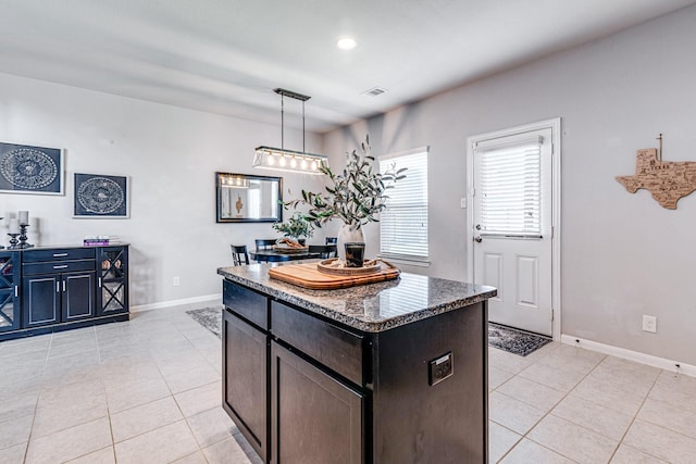 1100 Lasso Ct, Alvin, TX 77511 - kitchen featuring baseboards, decorative light fixtures, visible vents, and light tile patterned floors