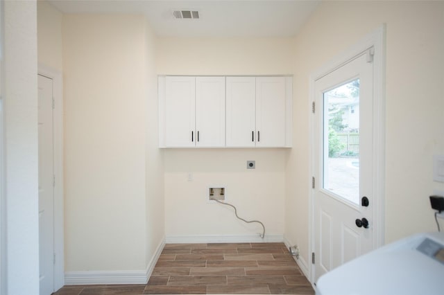 laundry room with electric dryer hookup, wood finish floors, visible vents, cabinet space, and hookup for a washing machine