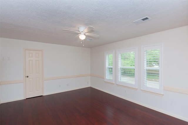 unfurnished room featuring baseboards, visible vents, ceiling fan, and dark wood-type flooring