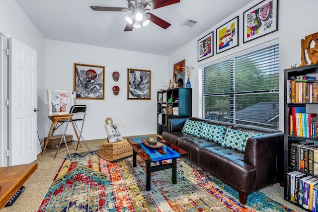 living area featuring baseboards, visible vents, and a ceiling fan
