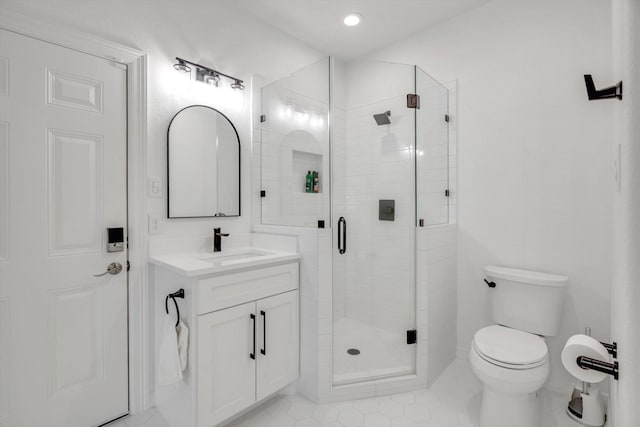 bathroom featuring toilet, vanity, and a stall shower