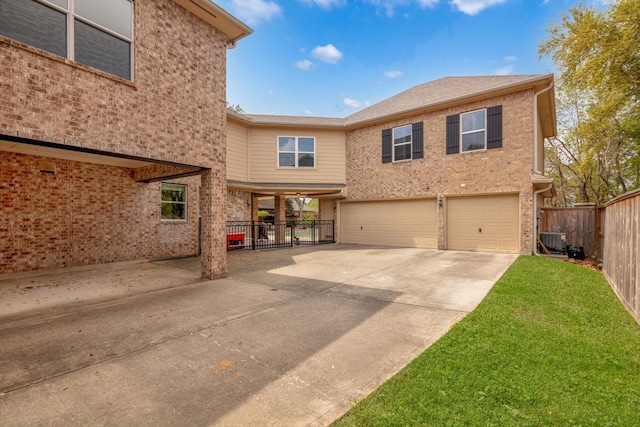 exterior space with fence, an attached garage, driveway, a front lawn, and central AC
