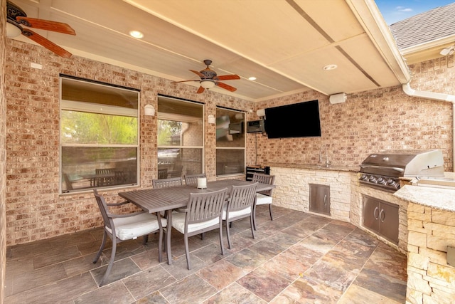 view of patio featuring a grill, outdoor dining space, area for grilling, and a ceiling fan