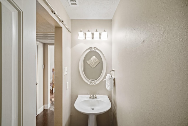 10515 Wind Walker Trl, Houston, TX 77095 - bathroom featuring a sink, a textured ceiling, baseboards, and visible vents