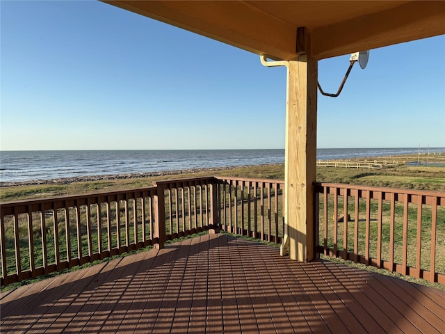wooden terrace with a view of the beach and a water view
