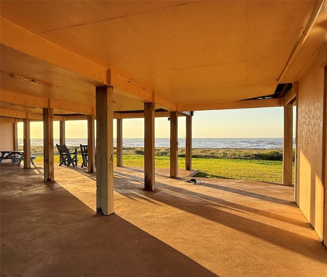 patio terrace at dusk with a beach view and a water view