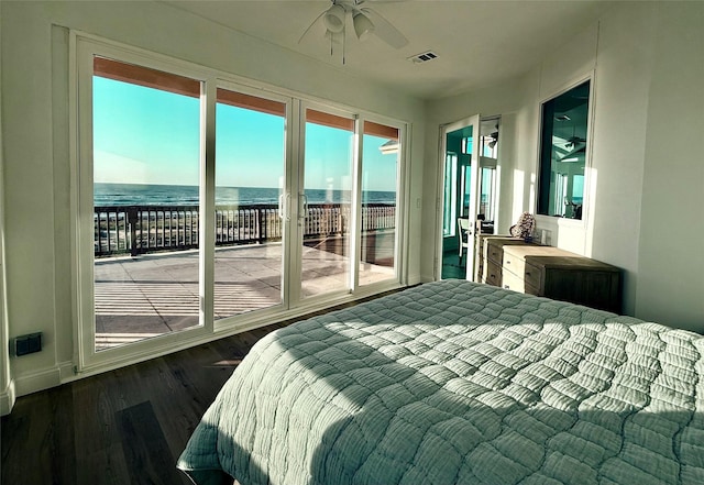 bedroom with a water view, access to exterior, visible vents, and wood finished floors