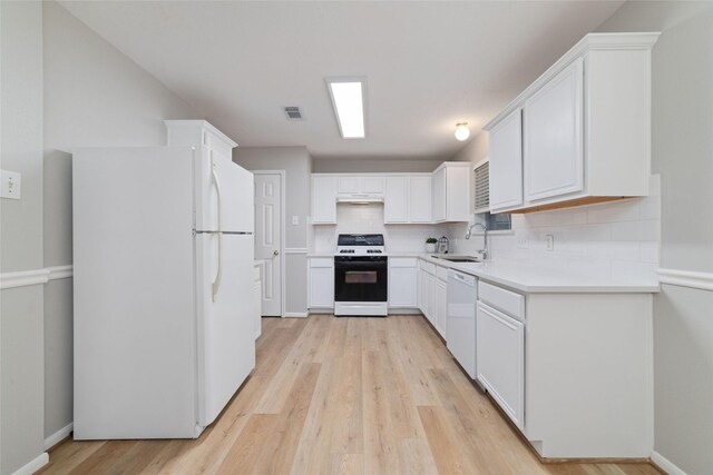 7014 Woodland Oaks, Magnolia, TX 77354 - kitchen with white appliances, a sink, tasteful backsplash, light wood-style floors, and white cabinets