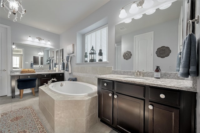 bathroom with two vanities, tile patterned flooring, a bath, visible vents, and a sink