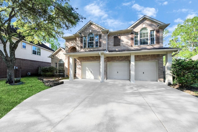 traditional-style house featuring driveway, a front lawn, and an attached garage