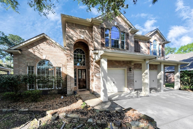 traditional-style home with driveway, an attached garage, and brick siding