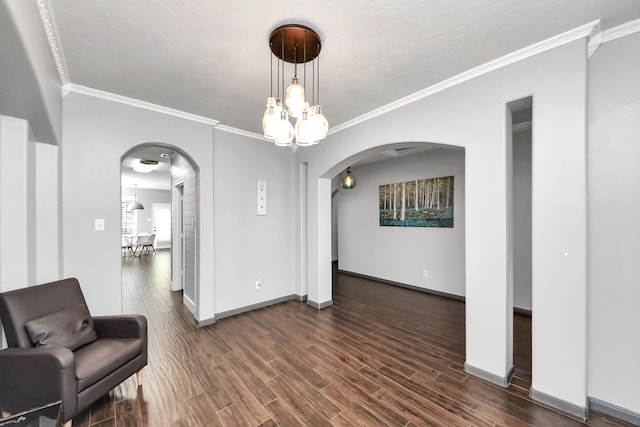 sitting room featuring baseboards, arched walkways, and dark wood-type flooring
