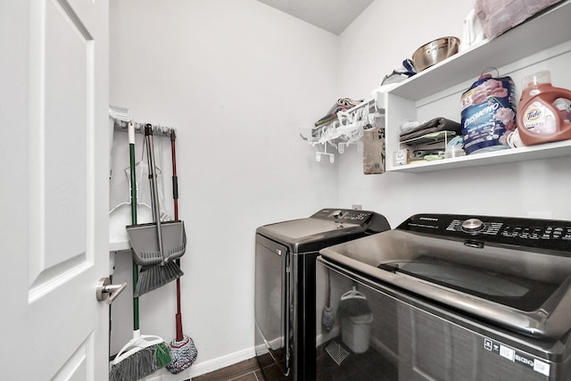 washroom featuring dark wood finished floors, baseboards, separate washer and dryer, and laundry area