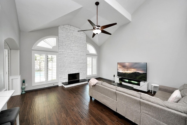 living room featuring plenty of natural light, a stone fireplace, ceiling fan, and wood finished floors