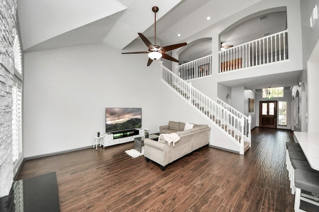 living room with high vaulted ceiling, ceiling fan, wood finished floors, recessed lighting, and stairway