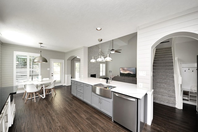 kitchen featuring stainless steel dishwasher, hanging light fixtures, dark wood-type flooring, and a ceiling fan