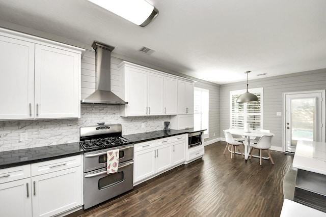 kitchen with visible vents, stainless steel appliances, dark wood-type flooring, white cabinetry, and wall chimney range hood