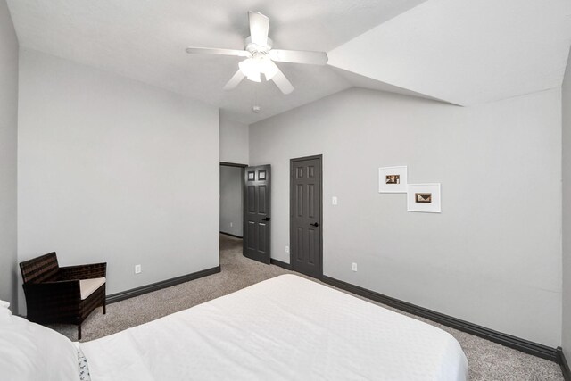 bedroom with a ceiling fan, carpet floors, baseboards, and lofted ceiling