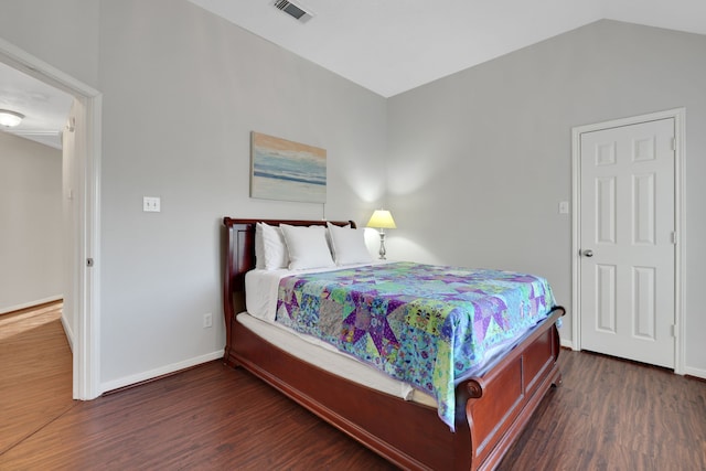 bedroom featuring baseboards, lofted ceiling, visible vents, and wood finished floors