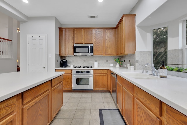 kitchen featuring a sink, light countertops, appliances with stainless steel finishes, and light tile patterned floors