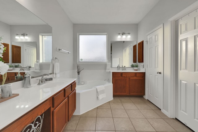bathroom featuring tile patterned flooring, a sink, two vanities, and a bath