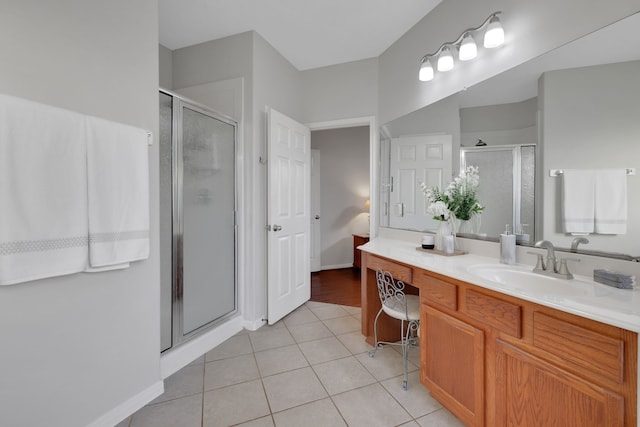 full bathroom featuring a shower stall, tile patterned floors, baseboards, and vanity