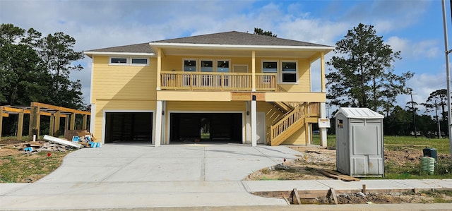 1909 Cindy Ct, Dickinson, TX 77539 - beach home featuring an attached garage, driveway, covered porch, stairs, and roof with shingles