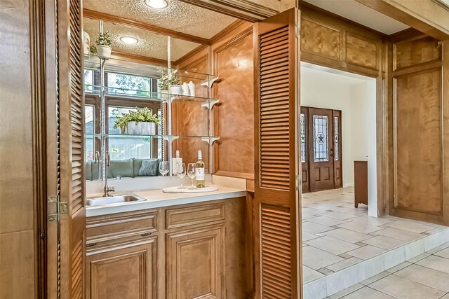 307 Crestwood Dr, El Lago, TX 77586 - bathroom featuring tile patterned flooring, a sink, double vanity, and a textured ceiling