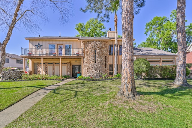 307 Crestwood Dr, El Lago, TX 77586 - view of front of property featuring a balcony, a chimney, stone siding, and a front yard