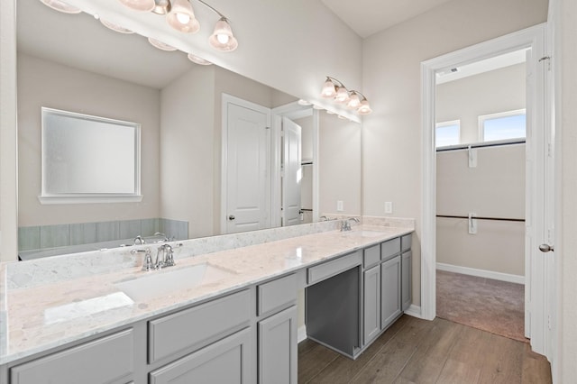 1922 Peacock Isle Dr, Dickinson, TX 77539 - bathroom featuring wood finished floors, double vanity, a spacious closet, and baseboards