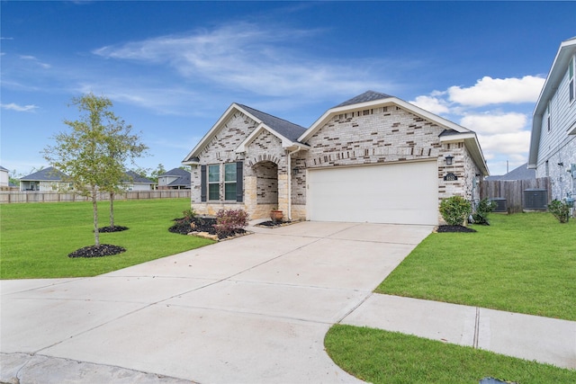 view of front of house with concrete driveway, fence, an attached garage, a front lawn, and central AC