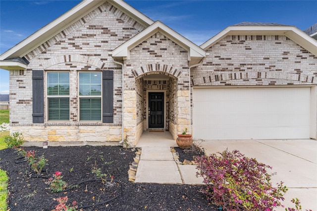 view of front of house featuring brick siding, concrete driveway, and a garage