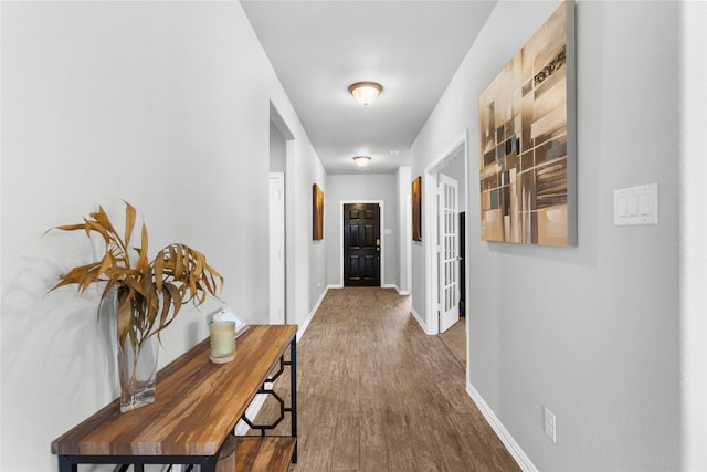 hallway featuring baseboards and wood finished floors