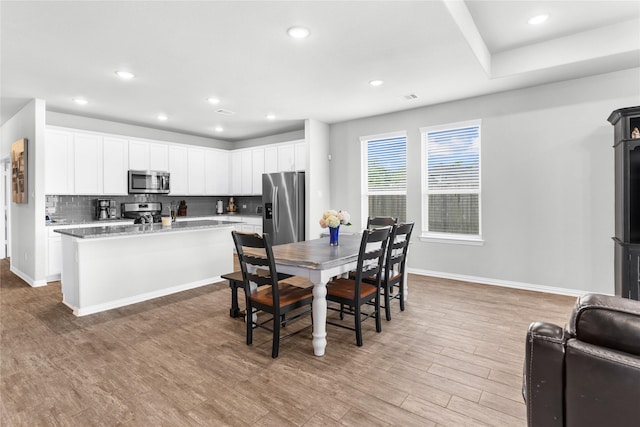 dining space featuring light wood-style flooring, visible vents, baseboards, and recessed lighting