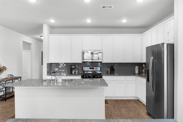 kitchen with visible vents, white cabinets, wood finished floors, and appliances with stainless steel finishes