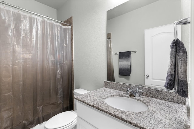bathroom with a textured wall, curtained shower, toilet, and vanity