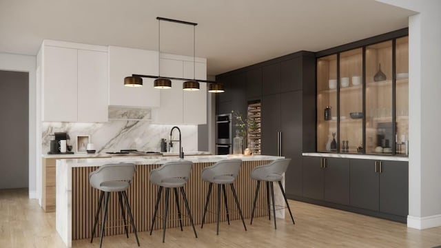 kitchen with a sink, modern cabinets, and a kitchen breakfast bar