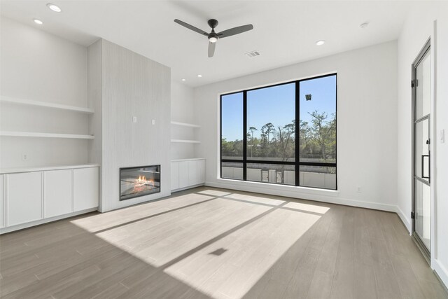 12838 Verdi Dr, Houston, TX 77024 - unfurnished living room with a fireplace, visible vents, wood finished floors, and built in features