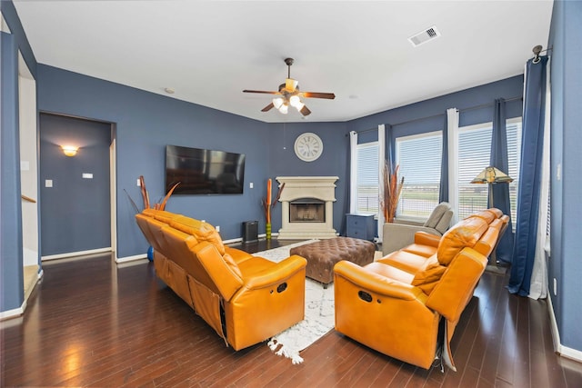 6226 Oxford Lake Dr, Rosenberg, TX 77471 - living room featuring hardwood / wood-style flooring, a fireplace with raised hearth, visible vents, ceiling fan, and baseboards