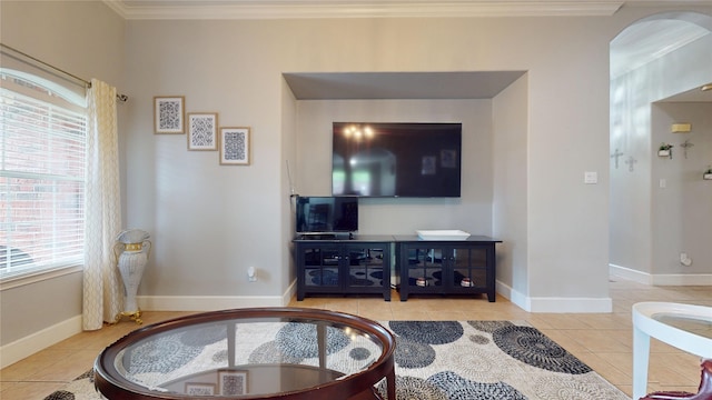 living area with tile patterned flooring, ornamental molding, baseboards, and arched walkways