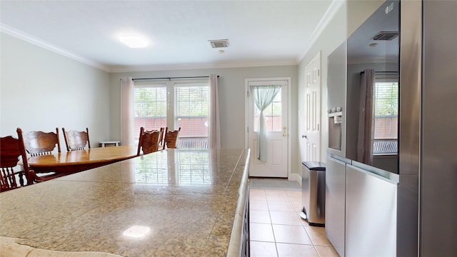 kitchen featuring visible vents, tile counters, crown molding, high end fridge, and light tile patterned floors