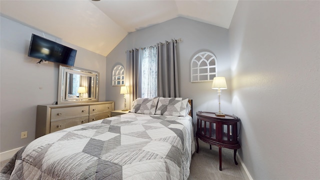 carpeted bedroom featuring baseboards and lofted ceiling