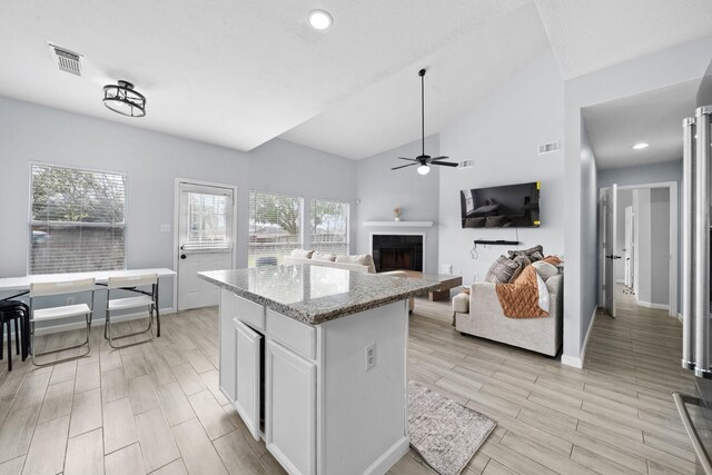 13619 Bonilla Ln, Houston, TX 77083 - kitchen featuring white cabinetry, a fireplace, visible vents, and a ceiling fan