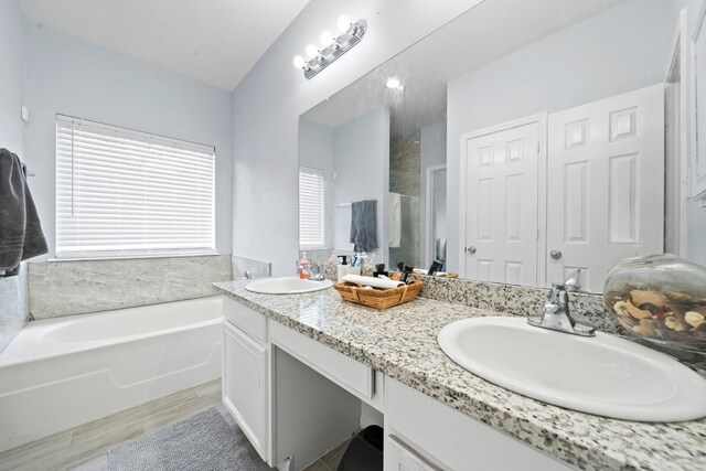 13619 Bonilla Ln, Houston, TX 77083 - bathroom featuring a stall shower, double vanity, a sink, and a garden tub