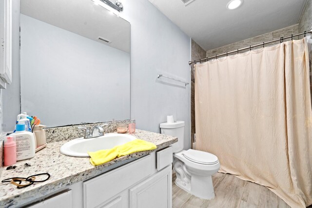 13619 Bonilla Ln, Houston, TX 77083 - full bathroom featuring visible vents, toilet, wood finished floors, curtained shower, and vanity