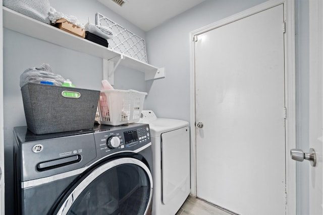 13619 Bonilla Ln, Houston, TX 77083 - washroom featuring visible vents, washer and dryer, laundry area, and wood finished floors