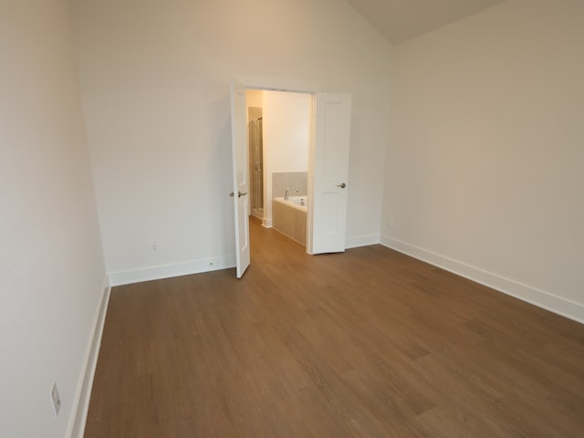 16208 Mcdonald County Ct, Montgomery, TX 77316 - empty room with dark wood-style floors, baseboards, and lofted ceiling
