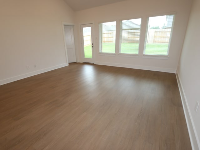 16208 Mcdonald County Ct, Montgomery, TX 77316 - unfurnished room featuring healthy amount of natural light, wood finished floors, and vaulted ceiling