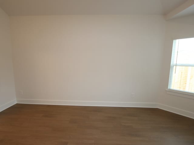 16208 Mcdonald County Ct, Montgomery, TX 77316 - unfurnished room featuring dark wood-type flooring, baseboards, and lofted ceiling