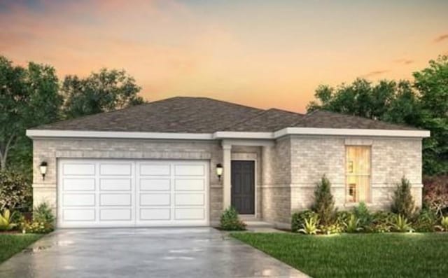 view of front of home featuring driveway, brick siding, and a garage